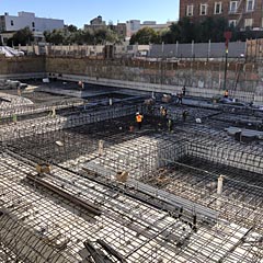 Construction workers setting up rebar for building foundation